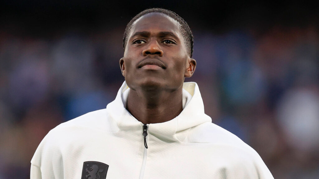 Aston Villa midfielder Amadou Onana stands in a warm-up jacket before. a game.