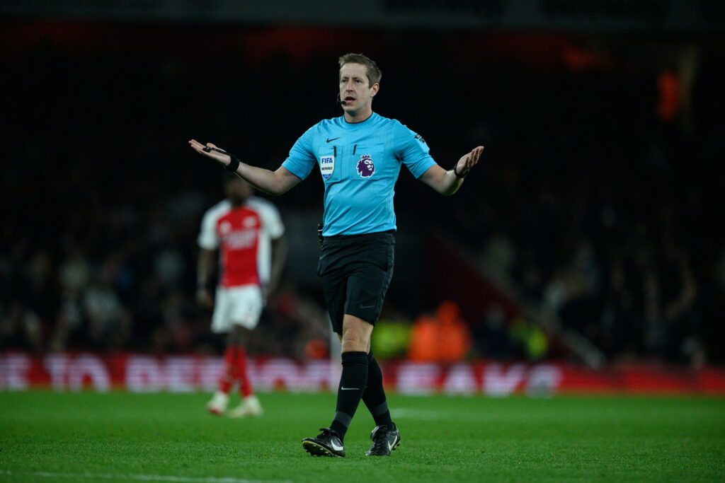 Premier League referee John Brooks holds out his hands